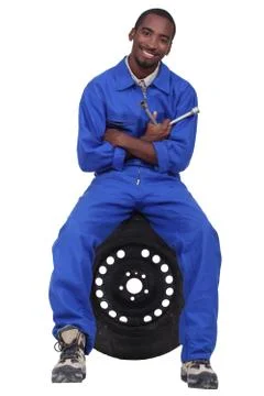 Mechanic sitting on a wheel Stock Photos
