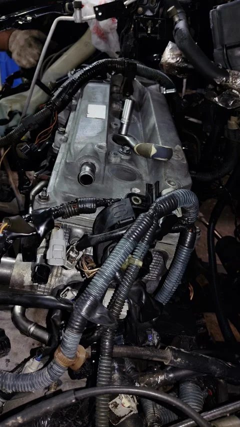 Mechanic socket wrench lying on a silver car engine valve cover Stock Footage 340415372