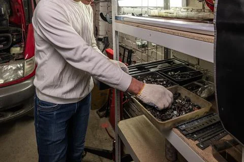 Mechanic sorting bolts and nuts in workshop Stock Photos