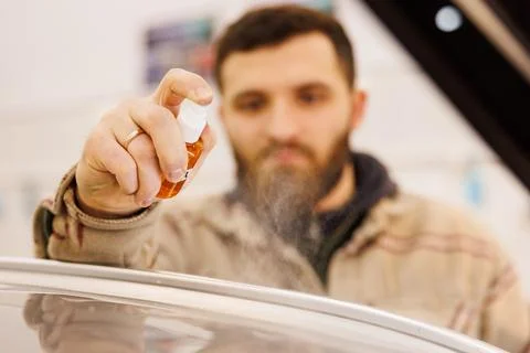 The mechanic sprays the surface to be processed on a car affected by hail Stock-Fotos
