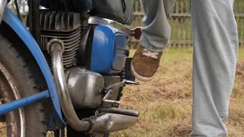 Mechanic starting old motorcycle engine with kick starter Video stock 314952129