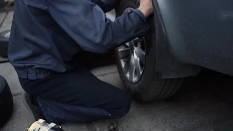 Mechanic Swaps Summer Tires for Winter Tires Stock-Footage 297090553