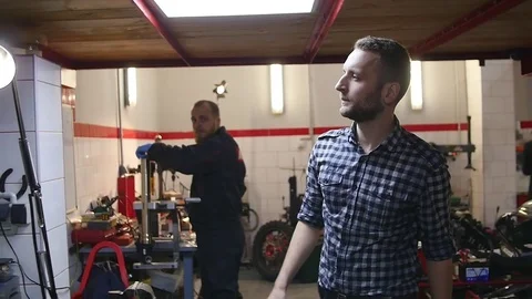 Mechanic taking a tool from wall at the repair garage Stock Footage