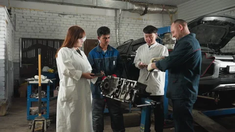 Mechanic Teaching Students Engine Repair in Automotive Workshop Stock Footage 301251355