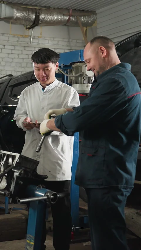 Mechanic Teaching Students Engine Repair in Automotive Workshop Stock Footage 318238944