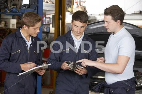 Mechanic Teaching Trainees In Garage Workshop Stock Photos