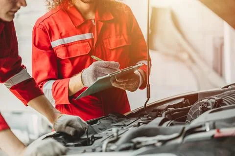 Mechanic team check list engine repair maintenance oil liquid change at fro.. Fotos de archivo