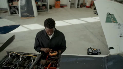Mechanic Testing Aircraft Engine Components with Multimeter in Hangar Stock Footage 310850504