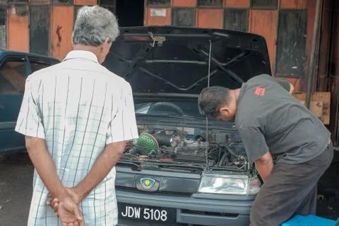 Mechanic testing headlight bulb with electric screwdrivers in a car  at the r Stock Photos