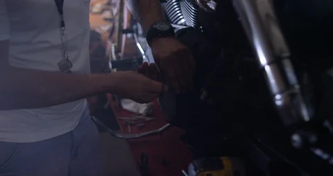 Mechanic tightening the nut of motorcycle engine in shop Stock Footage 116361209