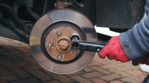 Mechanic tightening puller tool to remove seized brake disc from wheel hub Vídeo Stock 343509843
