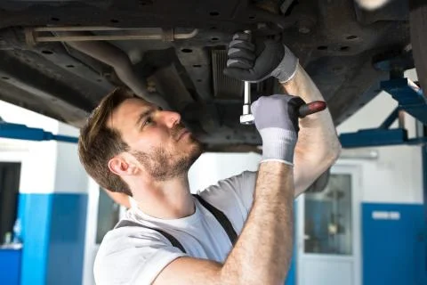 Mechanic with a tool under the car Stock Photos