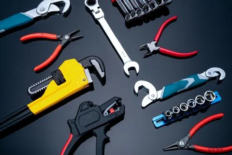 Mechanic tools on black background. Set of pipe wrench, bent wrench, nuts, .. Stock Photos
