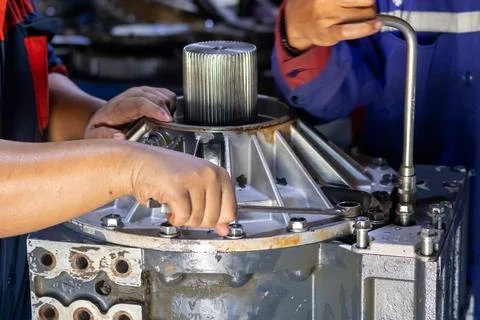 A mechanic turns a socket handle wrench to fasten gearbox housing bolts ind.. Foto stock