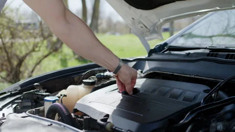Mechanic under open hood wraps up final checks car functionality restored Video stock 273767424