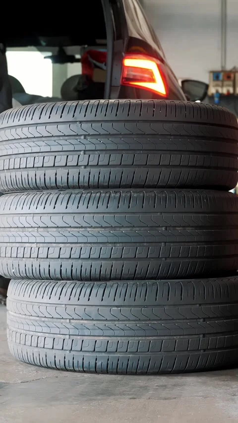 Mechanic Unloading Car Tires from Trunk Stacking Them for Replacement Stock Footage 332827416