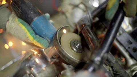 Mechanic use angle grinder machine on motorcycle metal frame Stock Footage 128920725