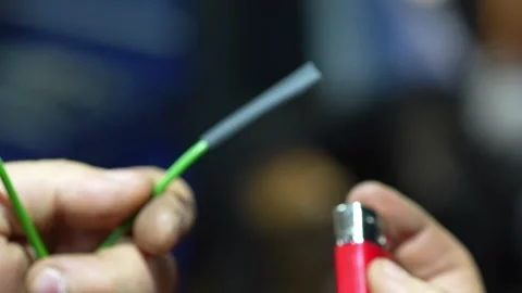 Mechanic uses a lighter flame to heat shrink automotive wire. Stock Footage 345910824