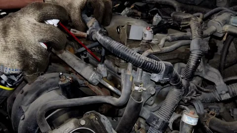 A mechanic uses a screwdriver to release engine harness connectors. Stock Footage 339492018