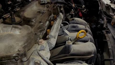 A mechanic uses a socket wrench extension to tighten intake manifold bolts. Stock Footage 339492441