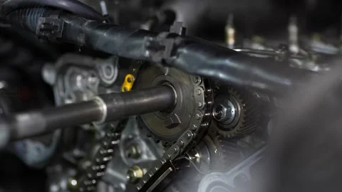 A mechanic uses a socket wrench to tighten or loosen a center bolt on a camsh Stock Footage 345108198