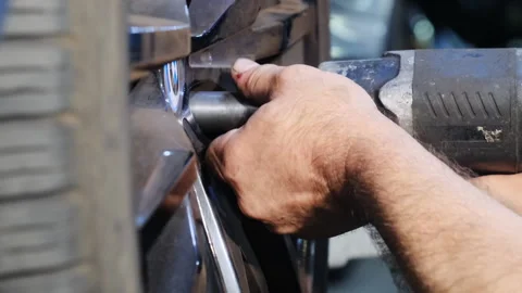 Mechanic uses special tool to screw nuts into wheel Stock Footage 317633108