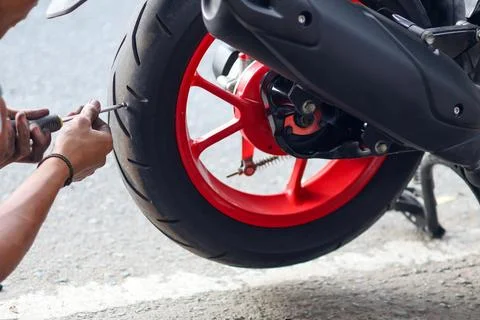 ​A mechanic uses a tool to remove a sharp metal screw Foto stock