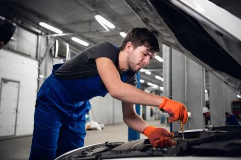 A mechanic uses tools to fix a car engine Stock Photos