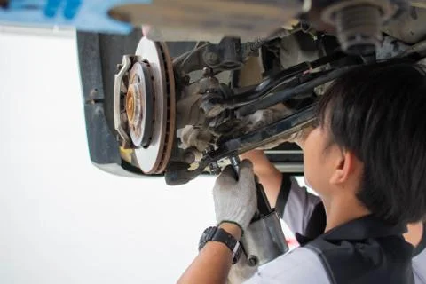 The mechanic uses tools to fix the disc brakes and the suspension of the car. Foto stock