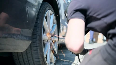 A mechanic uses a welding machine to weld a bolt to an old broken bolt Stock Footage 306883329