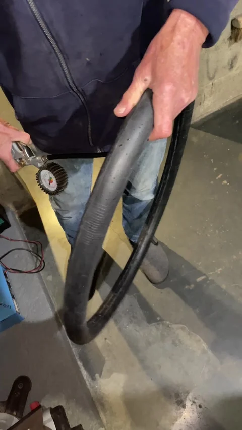 Mechanic using an air compressor to inflate a bicycle tire, step five Vídeo Stock 334048107