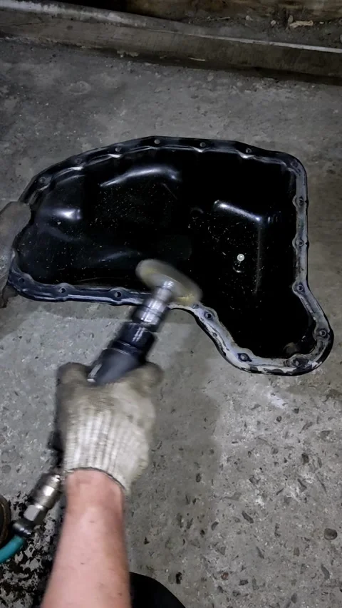A mechanic using an air die grinder with a wire brush wheel to clean old sea Stock Footage 336559739
