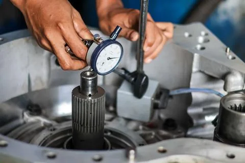Mechanic using dial indicator on car transmission. Stock Photos