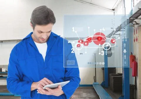 Mechanic using digital tablet against digital interface at workshop Stock Photos