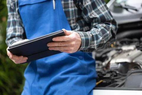 Mechanic using digital tablet for checking car engine Foto stock