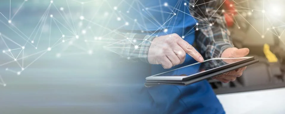 Mechanic using digital tablet for checking car engine; panoramic banner Fotos de archivo