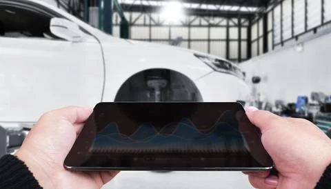 Mechanic using digital tablet with diagnostic graphs in auto repair shop Stock Photos