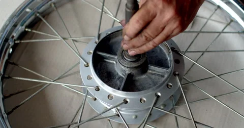 Mechanic using a hammer to install wheel bearings into a motorcycle hub. Stock Footage 311664842