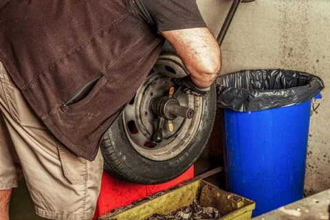 Mechanic using hand tools to balance a wheel Stock Photos