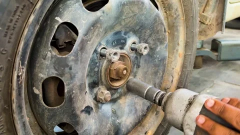Mechanic Using Impact Wrench To Remove Wheel Lug Nuts During Car Tire Service Stock Footage 339476776