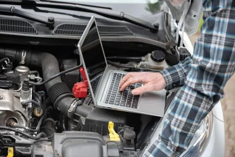 Mechanic using laptop for checking car engine Stock Photos