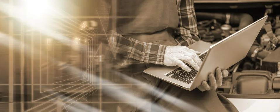 Mechanic using laptop for checking car engine; multiple exposure 写真素材