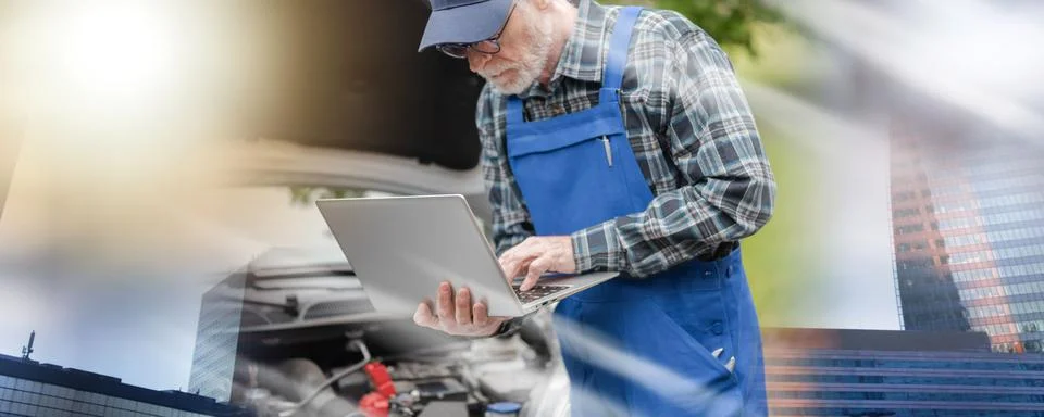 Mechanic using laptop for checking car engine; multiple exposure Fotos de archivo