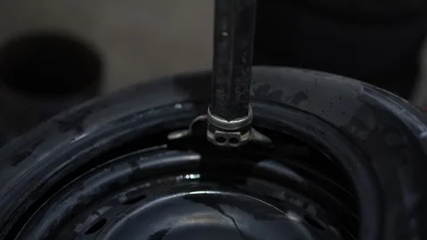 A mechanic using a machine to mount a tire on a rim. Stock Footage 331941001