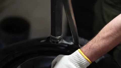 A mechanic using a machine to mount a tire on a rim. Stock Footage 331941079