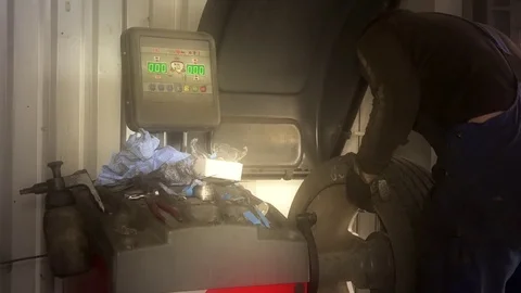Mechanic using modern computerized equipment for car tire balancing Stock Footage 81220649