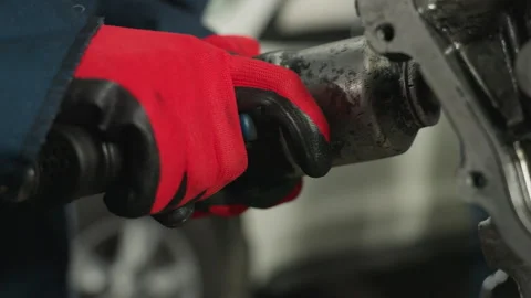 Mechanic Using Pneumatic Tool on Engine Block in Industrial Workshop Stock Footage 304972740