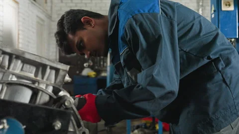 Mechanic Using Pneumatic Tool to Repair Engine Block in Industrial Workshop Stock Footage 303064990