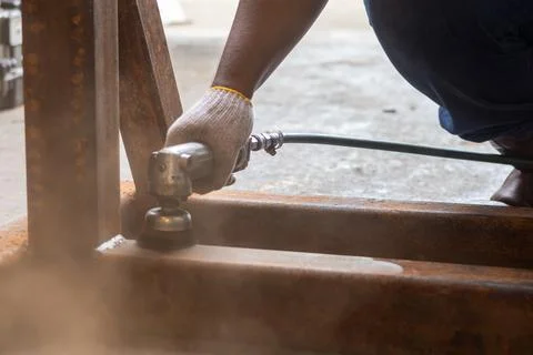 Mechanic using pneumatic wire cup brush to clean rusty steel frame...2. Des.. 스톡 사진