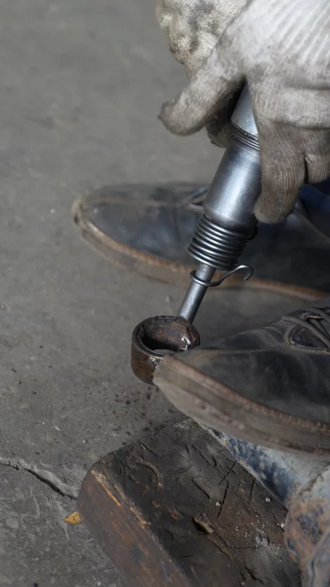 Mechanic Using Power Tool to Remove Rusty Part from Boot Sole Stock Footage 345568484